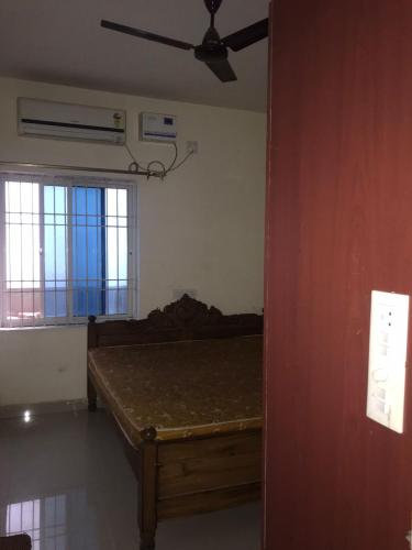 ブバネーシュワルにあるDDM Avenueのベッドと天井扇風機のある寝室