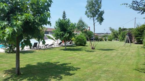 un parc avec une balançoire installée dans la pelouse dans l'établissement Logis Gascons, à Saint-Justin