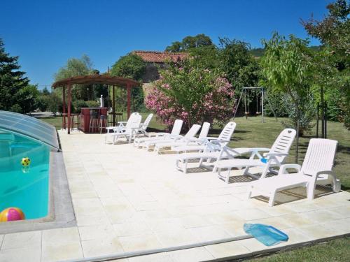 - un groupe de chaises longues blanches et une piscine dans l'établissement Logis Gascons, à Saint-Justin
