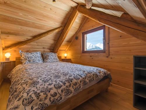 Un dormitorio con una cama en una cabaña de troncos en Gite Le Mazot, en Albiez-Montrond