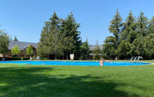 une personne debout dans l'herbe près d'une piscine dans l'établissement Duplex con piscina y wifi junto a Puigcerdà, à Palau-de-Cerdagne