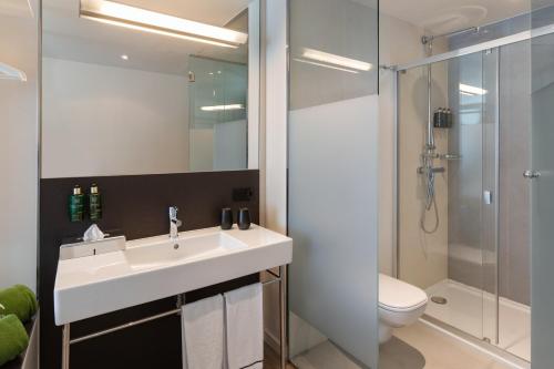 a bathroom with a sink and a shower and a toilet at Meliá South Beach in Magaluf