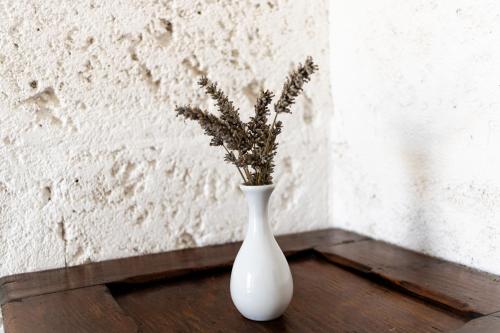 a white vase with flowers in it sitting on a table at Corte Mercurio B&B in Ugento