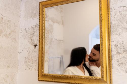 a man and a woman kissing in a mirror at Corte Mercurio B&B in Ugento