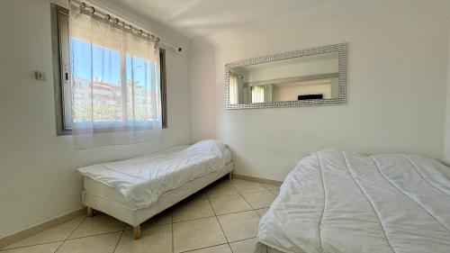 une chambre avec un lit et un miroir au mur dans l'établissement Appartement 3 pièces - Proche Centre Cannes, à Cannes