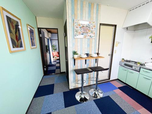 a kitchen with a counter and two stools in it at Belmont 303 3min to Station Easy Access Ueno Asakusa Skytree Sleeps 4 in Tokyo