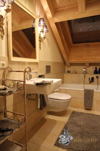 a bathroom with a sink and a toilet and a tub at Alpen-suite in Riezlern
