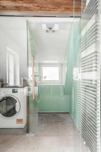a laundry room with a washing machine and a window at Goldene Pastete - Urban Luxury Apartments City Center in Graz