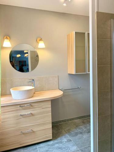 une salle de bain avec un lavabo et un miroir dans l'établissement Maison de village avec extérieur, à Anse