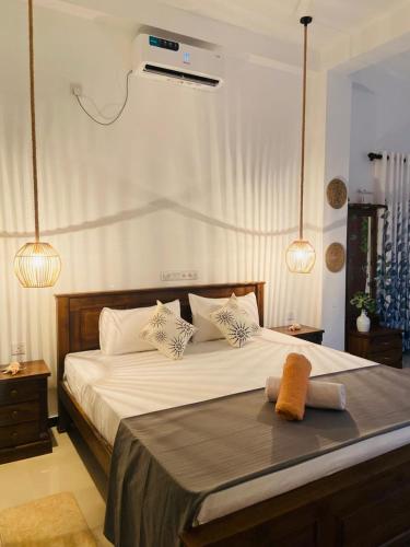 a bedroom with a bed with white sheets and pillows at Diamond Key Ahangama in Piyadigama