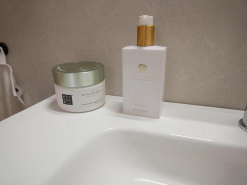 a bottle of moisturizing moisturizing cream and a bottle of medicine on a sink at Villa Donax in Sint Maartensvlotbrug