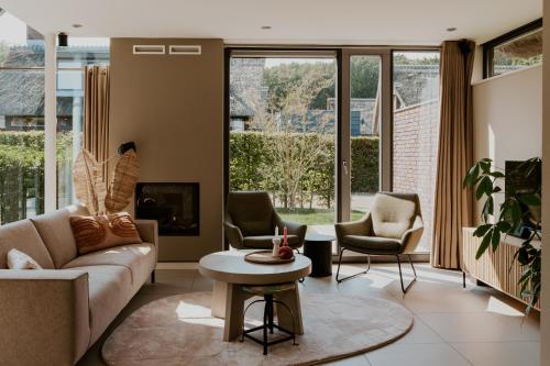a living room with a couch and chairs and a table at Dutchen Villapark Mooi Schoorl in Schoorl