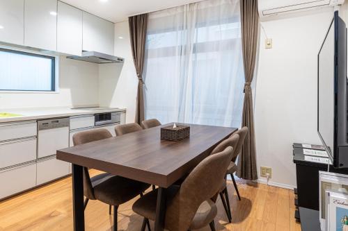 a kitchen and dining room with a wooden table and chairs at 上北沢戸建て in Tokyo