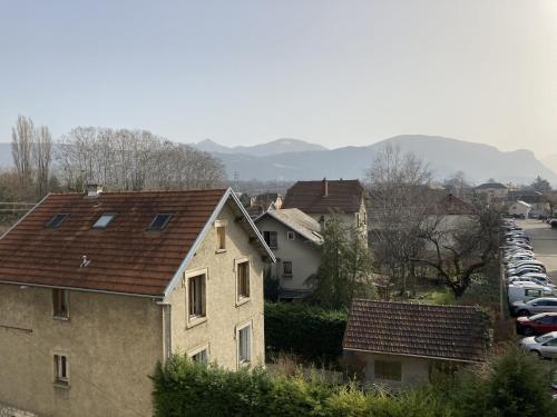 Une rangée de voitures garées sur un parking dans l'établissement petit studio vue montagne, à Chambéry