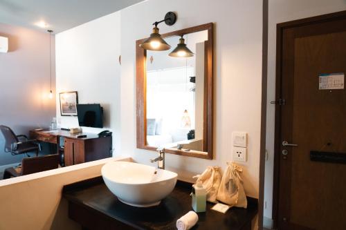 a bathroom with a sink and a large mirror at iRoHa Garden Hotel & Resort in Phnom Penh