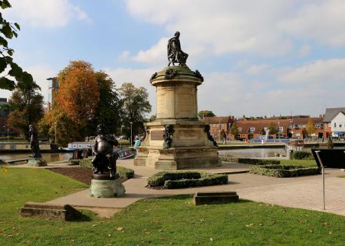a statue of a man standing on a monument in a park at Furlong Barn in Southam