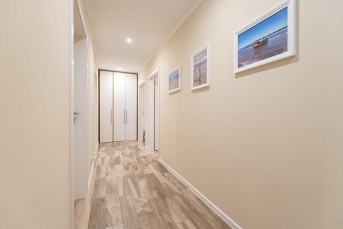 a hallway with white walls and wood flooring at Ferienhaus Seeadler in Kamminke