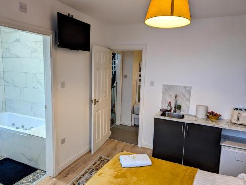 a kitchen with a sink and a tub in a room at Blok 3 -Jacuzzi Suites, Apartment & Ensuite Rooms in Blackpool