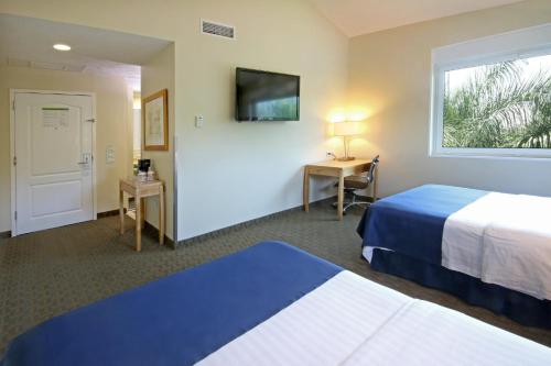 a hotel room with two beds and a window at Holiday Inn Cuernavaca by IHG in Cuernavaca