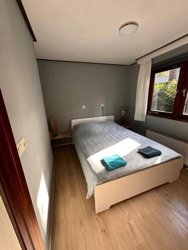 a bedroom with a bed with two towels on it at Het Vijverhuisje - Holiday only in Doornspijk