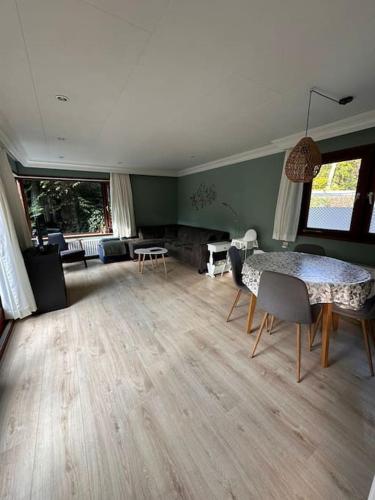 a living room with a table and chairs and a living room at Het Vijverhuisje - Holiday only in Doornspijk