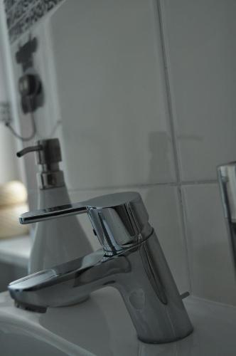um lavatório de casa de banho com uma torneira de prata em M&M Centrum Apartments em Poznań