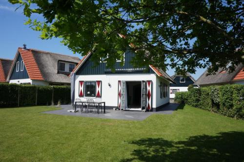 a house with a white and red garage at Buitenplaats Villa Deluxe in Callantsoog