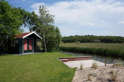 a small cabin on the side of a river at Buitenplaats Villa Deluxe in Callantsoog