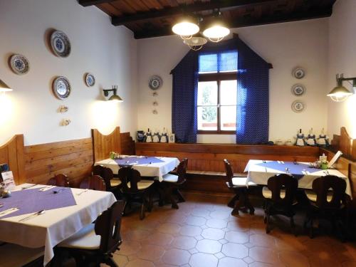 a dining room with tables and chairs and a window at Berki Vendéglő és Hotel in Körmend