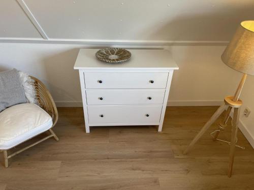 a bedroom with a white dresser and a lamp at Villa Lighthouse in Callantsoog
