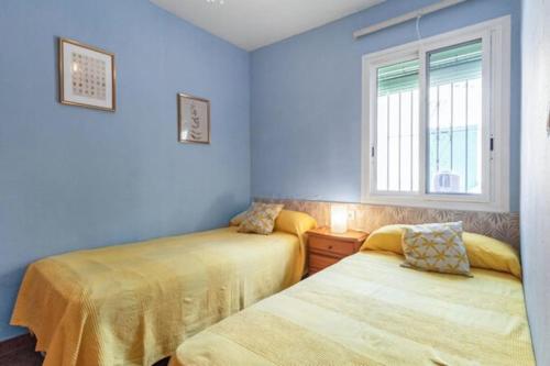 two beds in a room with blue walls at CASA CANDILES in Torrox Costa