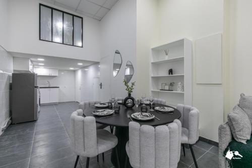 une salle à manger avec une table et des chaises noires dans l'établissement MBA - Lecourbe Splendide Appartement, à Paris