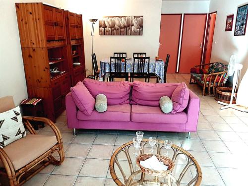 un salon avec un canapé violet et une table dans l'établissement Superbe villa de plain pied avec grand jardin - 6RADI8, à Saint Cyprien Plage