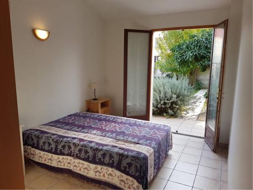 une chambre avec un lit et une porte ouverte dans l'établissement Superbe villa de plain pied avec grand jardin - 6RADI8, à Saint Cyprien Plage