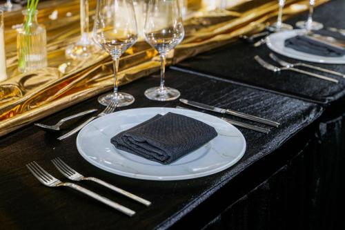 a plate with a napkin on a table with wine glasses at Hotel Indigo Wuxi Taihu New City in Wuxi