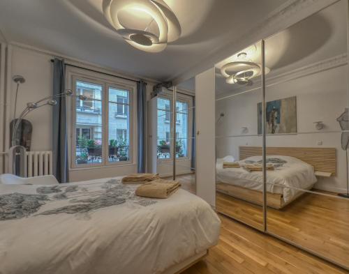 une chambre avec deux lits et une grande fenêtre dans l'établissement Luxury Place near Champs Elysees, à Paris