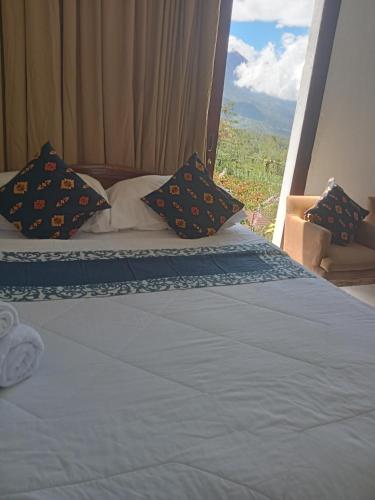 a bedroom with a bed with a view at The Bunut Villas in Kubupenlokan