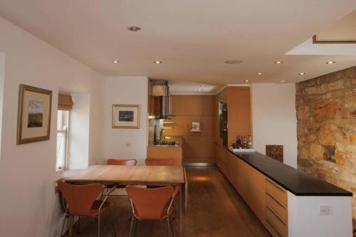 a kitchen and dining room with a table and chairs at Maybell Cottage, Your Luxury Seaside Pad in Pittenweem
