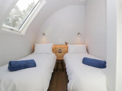 two beds in a small room with a window at Leadon View Oak in Newent