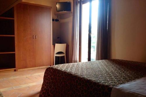 a bedroom with a bed and a window with a chair at LA FOLAGA b&b in Gavirate