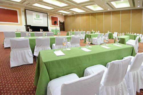 a conference room with green tables and white chairs at Holiday Inn Cuernavaca by IHG in Cuernavaca