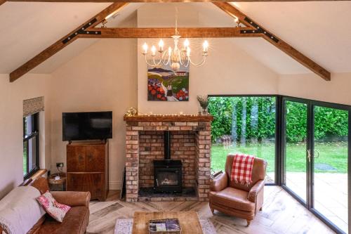 a living room with a fireplace and a tv at Bramble Cottage, hidden gem in Comber near Belfast in Comber