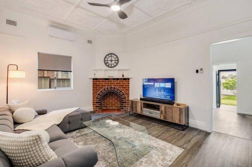 a living room with a couch and a tv at Spacious 3-Bedroom Family Home in Concord's Heart! in Sydney