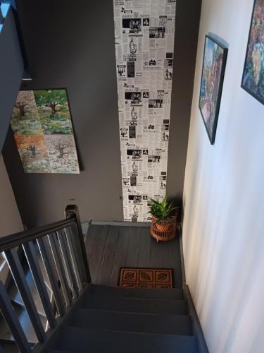 un escalier avec une affiche au mur et une plante dans l'établissement Central Park Studio, à Plovdiv