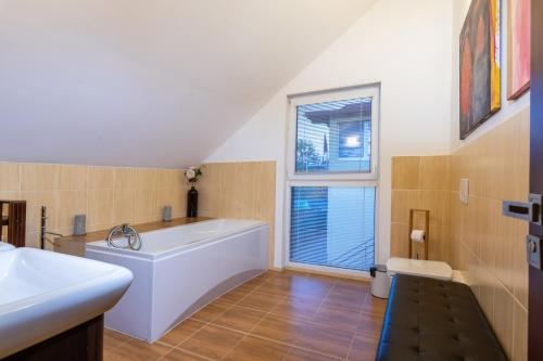利普托斯基米库拉斯Private holiday house Vivendi的带浴缸和盥洗盆的大浴室