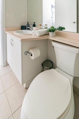 a bathroom with a white toilet and a sink at City View Towers - Steps to CN Tower - Pool & Hot tub - Free Parking in Toronto