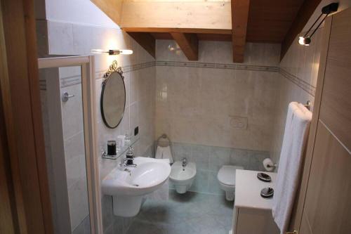 a bathroom with a sink and a toilet and a mirror at LA FOLAGA b&b in Gavirate