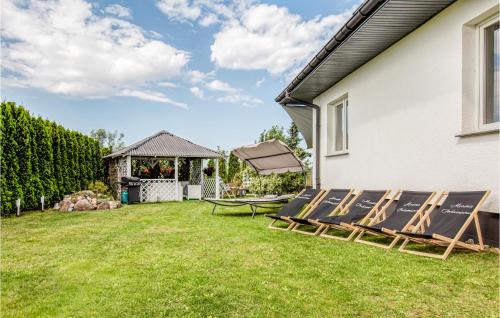 a yard with chairs and a table and a house at 3 Bedroom Gorgeous Home In Podamirowo in Podamirowo
