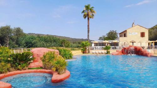 - une grande piscine dans une maison avec un palmier dans l'établissement Camping 4 étoiles - Parc aquatique - eec0ef, à Agay