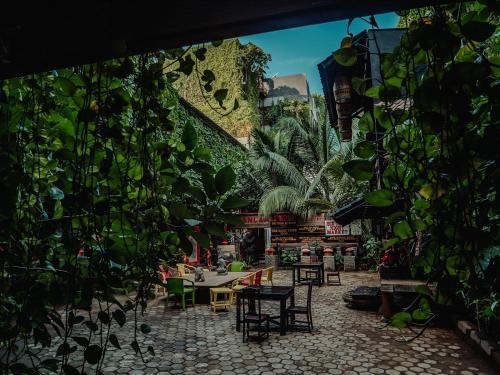 a room with a table and chairs and plants at House of Tugu, Old Town Jakarta in Jakarta